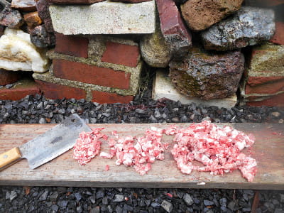 I'm chopping up bite-sized pieces of meaty lamg boes for my dog